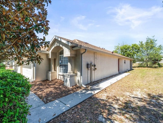 3885 Crossline Dr, Spring Hill, FL 34609 - view of side of home with stucco siding and a garage