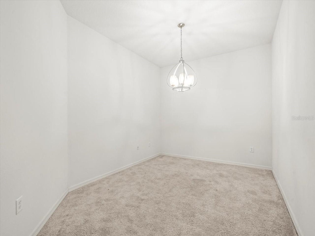 3885 Crossline Dr, Spring Hill, FL 34609 - spare room featuring carpet, a chandelier, and baseboards