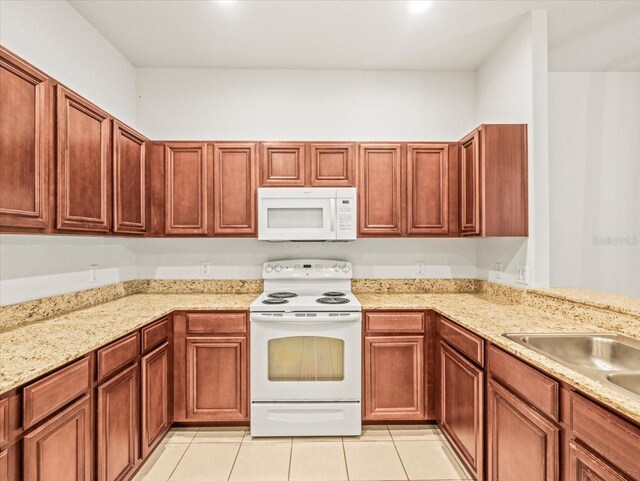 3885 Crossline Dr, Spring Hill, FL 34609 - kitchen with white appliances, light tile patterned floors, light stone counters, and a sink