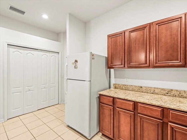 3885 Crossline Dr, Spring Hill, FL 34609 - kitchen featuring freestanding refrigerator, light tile patterned floors, light stone counters, and recessed lighting