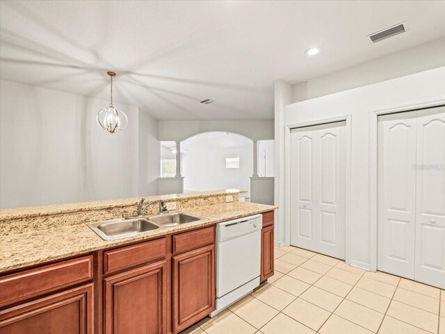 3885 Crossline Dr, Spring Hill, FL 34609 - kitchen with white dishwasher, a sink, arched walkways, light tile patterned floors, and light stone counters