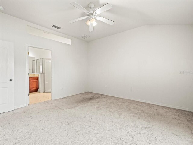 3885 Crossline Dr, Spring Hill, FL 34609 - unfurnished bedroom with light colored carpet, ensuite bathroom, baseboards, lofted ceiling, and a ceiling fan