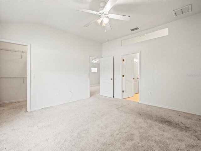 3885 Crossline Dr, Spring Hill, FL 34609 - unfurnished bedroom with carpet flooring, a walk in closet, a closet, ensuite bath, and vaulted ceiling