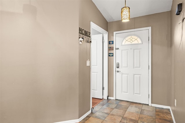 foyer entrance with baseboards and stone finish floors
