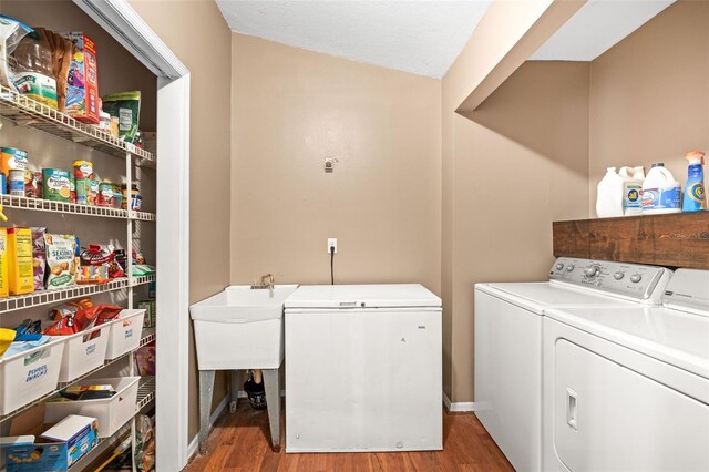 laundry area featuring separate washer and dryer and wood finished floors