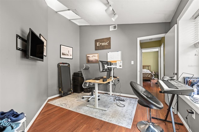 office area featuring wood finished floors, baseboards, and rail lighting
