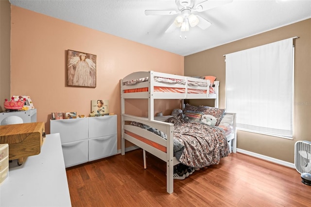 bedroom featuring wood finished floors, ceiling fan, and baseboards