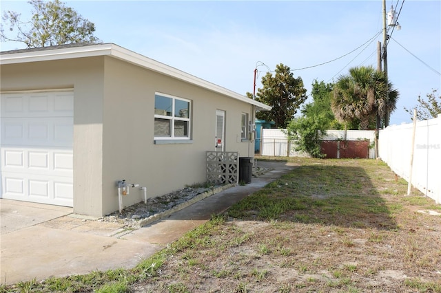 view of side of home featuring fence and stucco siding