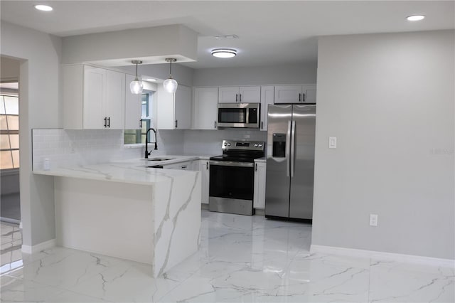 kitchen with appliances with stainless steel finishes, backsplash, a peninsula, baseboards, and light stone countertops