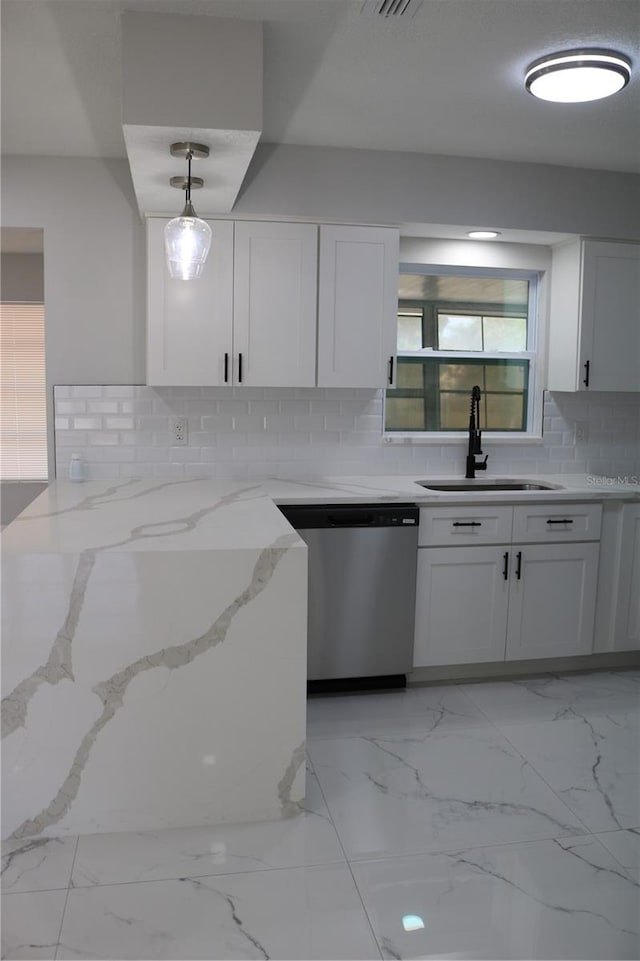 kitchen with stainless steel dishwasher, a sink, light marble finish floors, white cabinets, and light stone countertops