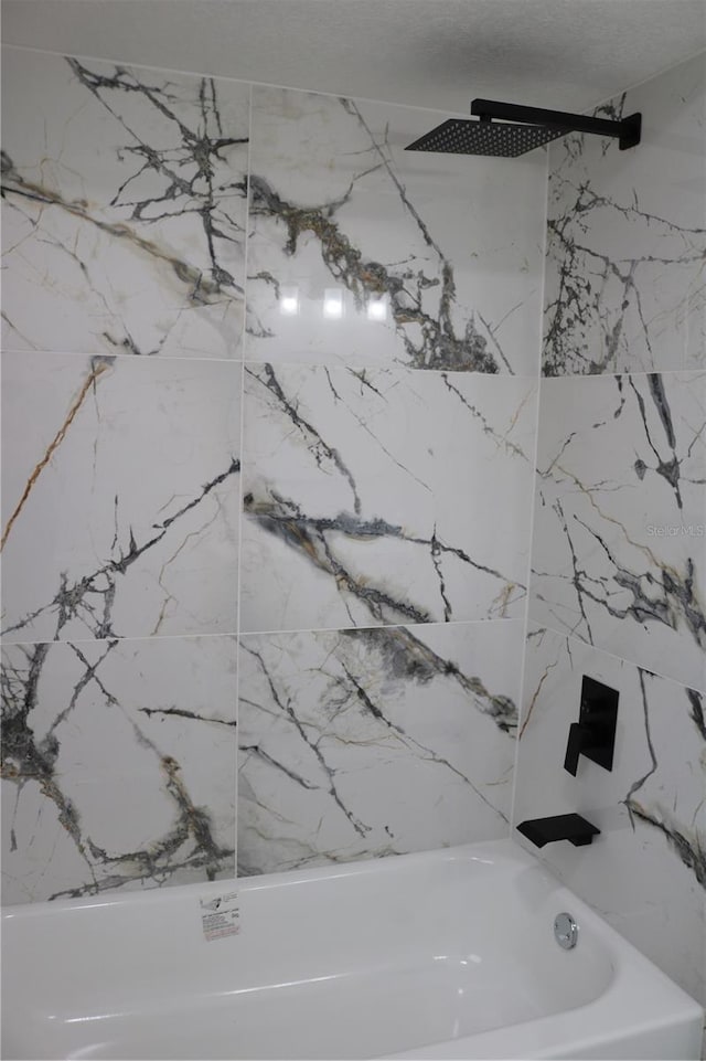 bathroom view of washtub / shower combination