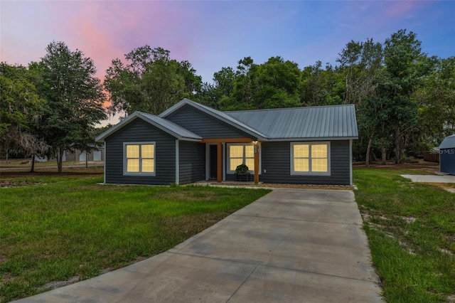 1161 Crk 443, Lake Panasoffkee, FL 33538 - view of front of house with a front yard, metal roof, and concrete driveway