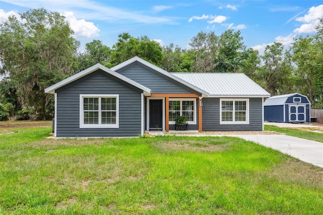 1161 Crk 443, Lake Panasoffkee, FL 33538 - view of front of home with a shed, a front lawn, an outdoor structure, and metal roof