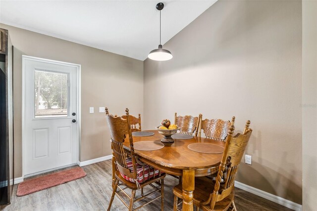 1161 Crk 443, Lake Panasoffkee, FL 33538 - dining area featuring wood finished floors, baseboards, and vaulted ceiling