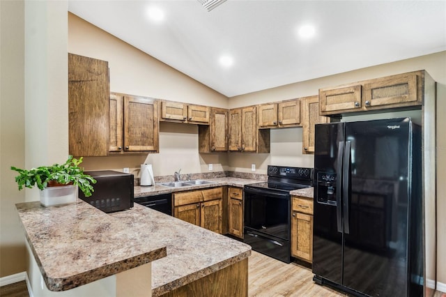 1161 Crk 443, Lake Panasoffkee, FL 33538 - kitchen featuring black appliances, a peninsula, vaulted ceiling, light wood-type flooring, and light countertops