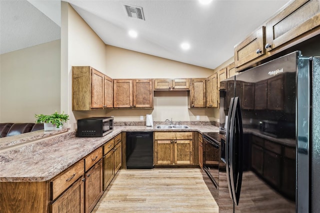 1161 Crk 443, Lake Panasoffkee, FL 33538 - kitchen with black appliances, lofted ceiling, a sink, light wood-type flooring, and light countertops