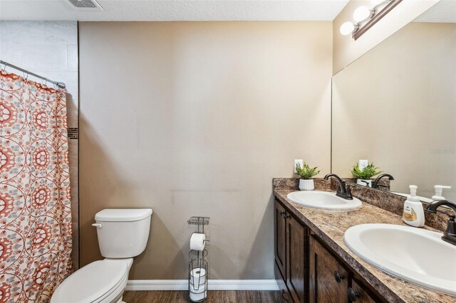1161 Crk 443, Lake Panasoffkee, FL 33538 - bathroom with toilet, double vanity, wood finished floors, a shower with curtain, and baseboards