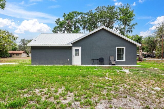 1161 Crk 443, Lake Panasoffkee, FL 33538 - back of house with a yard, stucco siding, and metal roof