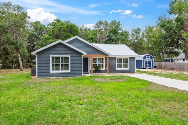 1161 Crk 443, Lake Panasoffkee, FL 33538 - view of front of house with a storage shed, central AC, an outbuilding, and metal roof