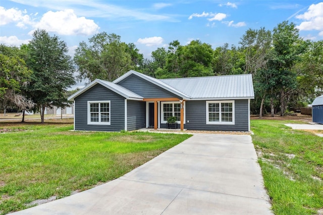 1161 Crk 443, Lake Panasoffkee, FL 33538 - view of front of property featuring a front lawn, metal roof, and driveway