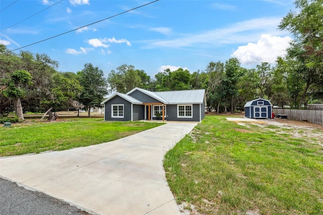 1161 Crk 443, Lake Panasoffkee, FL 33538 - ranch-style home with a storage shed, concrete driveway, an outdoor structure, view of wooded area, and metal roof
