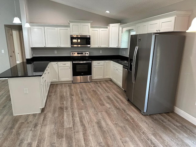 9252 N Agatha Dr, Citrus Springs, FL 34434 - kitchen featuring appliances with stainless steel finishes, lofted ceiling, white cabinetry, dark countertops, and recessed lighting