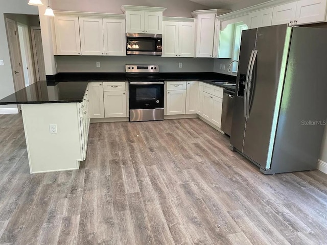 9252 N Agatha Dr, Citrus Springs, FL 34434 - kitchen featuring stainless steel appliances, light wood-style flooring, white cabinets, dark countertops, and vaulted ceiling