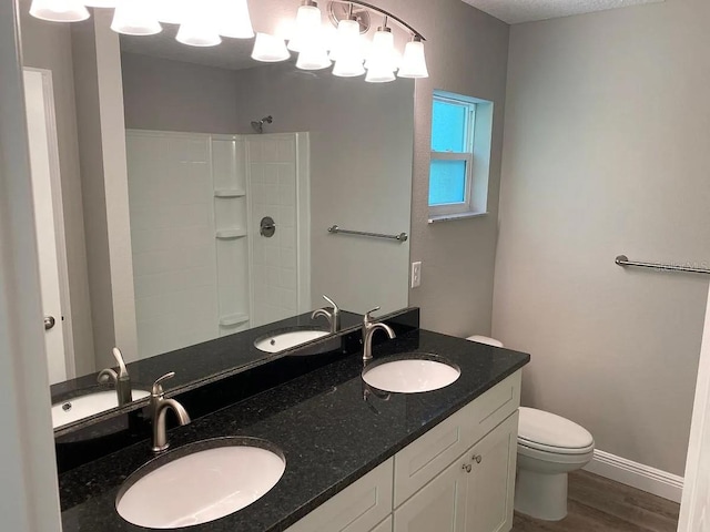 9252 N Agatha Dr, Citrus Springs, FL 34434 - full bathroom featuring toilet, a shower, wood finished floors, double vanity, and baseboards
