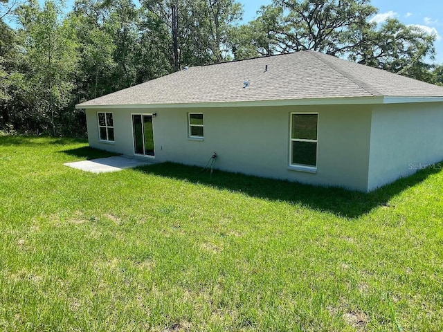 9252 N Agatha Dr, Citrus Springs, FL 34434 - rear view of house featuring a yard, stucco siding, a shingled roof, and a patio area