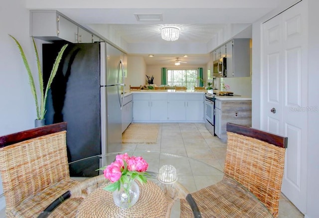 kitchen with stainless steel appliances, light countertops, light tile patterned floors, and ceiling fan