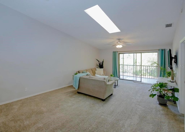living area featuring carpet flooring, a skylight, a ceiling fan, and baseboards