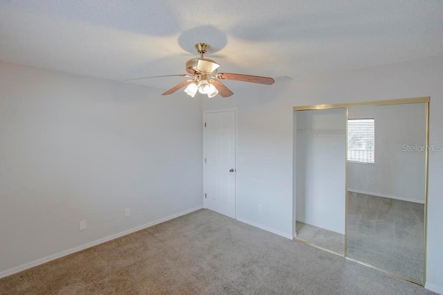 unfurnished bedroom featuring carpet, a closet, a ceiling fan, and baseboards