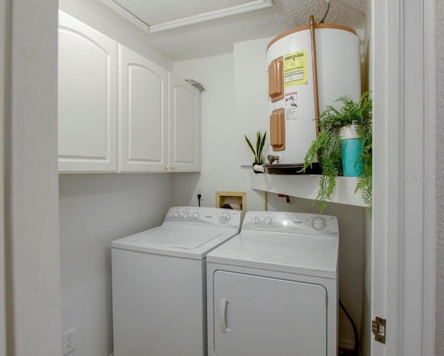 laundry room with water heater, washing machine and clothes dryer, cabinet space, and a textured ceiling