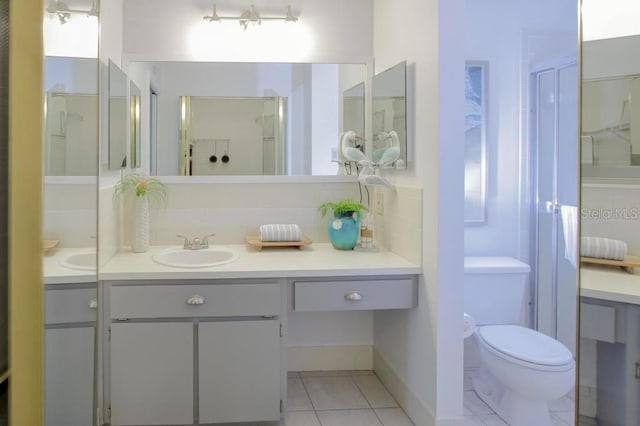 bathroom featuring tile patterned flooring, toilet, a stall shower, and vanity