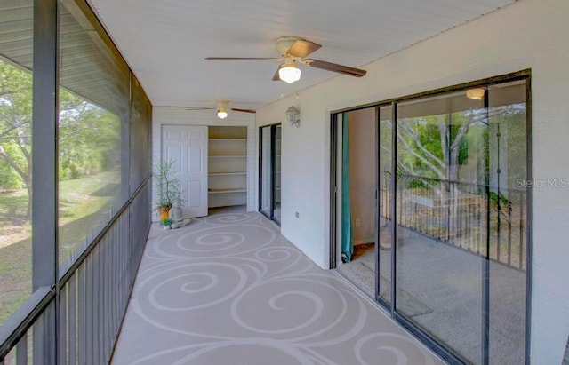 unfurnished sunroom featuring ceiling fan