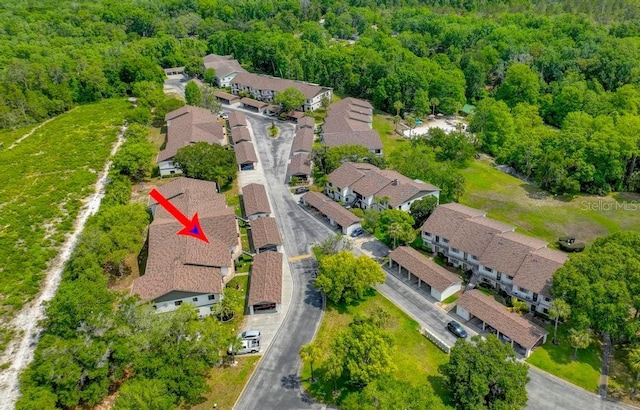 view of property location featuring a heavily wooded area and nearby suburban area