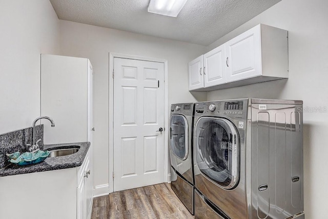 10910 Winter Oak Pl, Tampa, FL 33618 - laundry room featuring washer and dryer, wood finished floors, cabinet space, and a textured ceiling