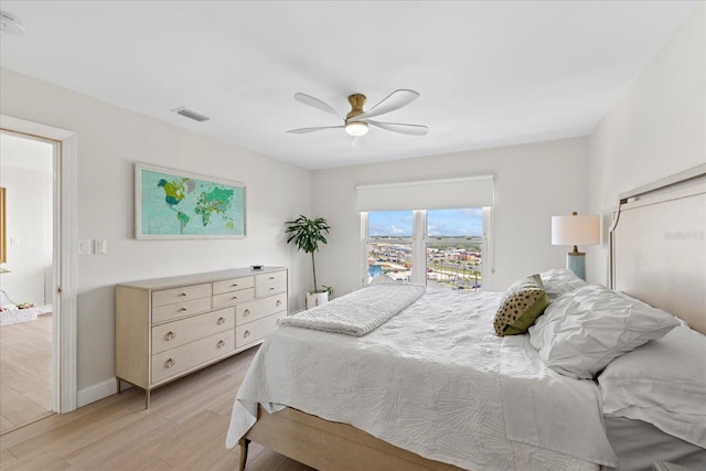 bedroom with light wood-style floors, ceiling fan, and baseboards