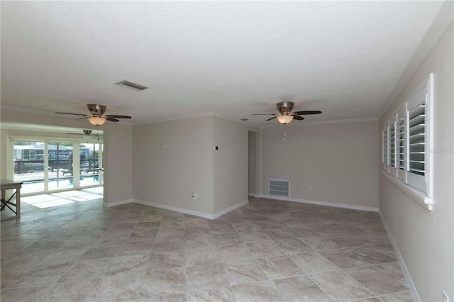 unfurnished room featuring a ceiling fan, stone finish flooring, a textured ceiling, ornamental molding, and baseboards