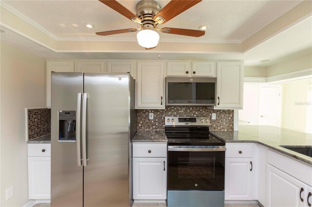 kitchen featuring stainless steel appliances, decorative backsplash, a ceiling fan, dark stone countertops, and crown molding
