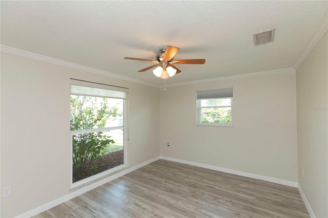 empty room featuring light wood finished floors, a ceiling fan, ornamental molding, baseboards, and a textured ceiling