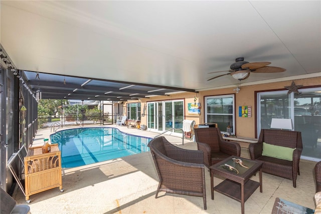 view of pool featuring a patio area, ceiling fan, a pool, glass enclosure, and an outdoor hangout area