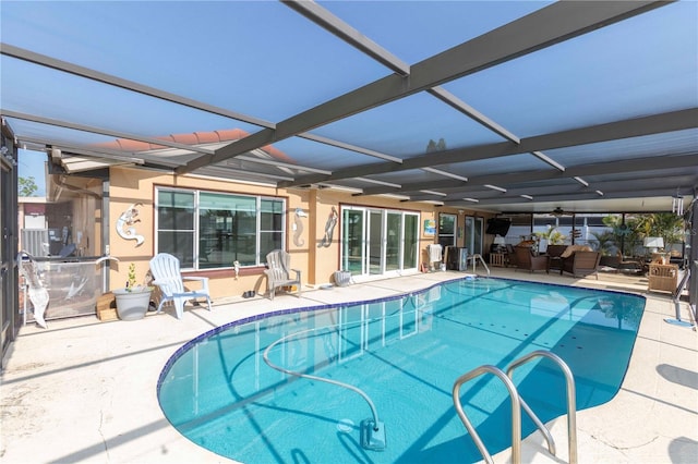 swimming pool with a patio area, a ceiling fan, and a lanai