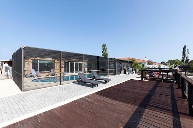 wooden deck featuring a patio and glass enclosure