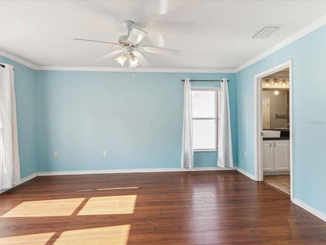 empty room featuring a ceiling fan, wood finished floors, crown molding, and baseboards