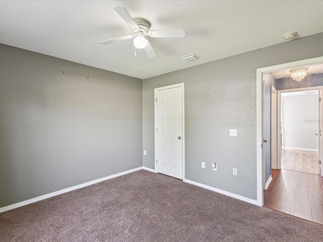 unfurnished bedroom with a chandelier, carpet, baseboards, and a ceiling fan