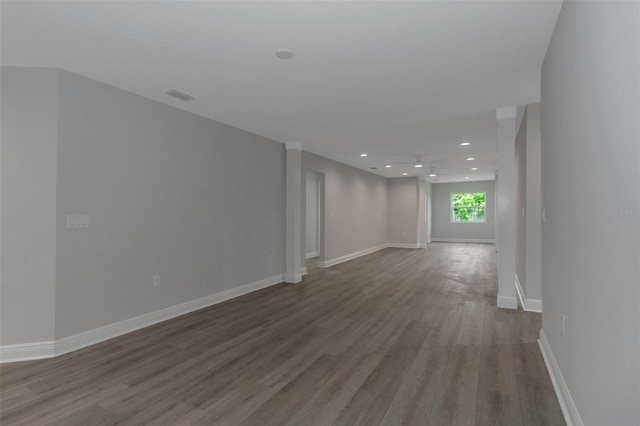 spare room featuring wood finished floors, baseboards, and recessed lighting