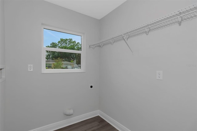 washroom featuring hookup for an electric dryer, baseboards, and dark wood-type flooring