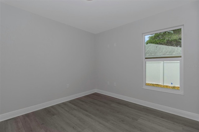 empty room featuring dark wood-type flooring and baseboards