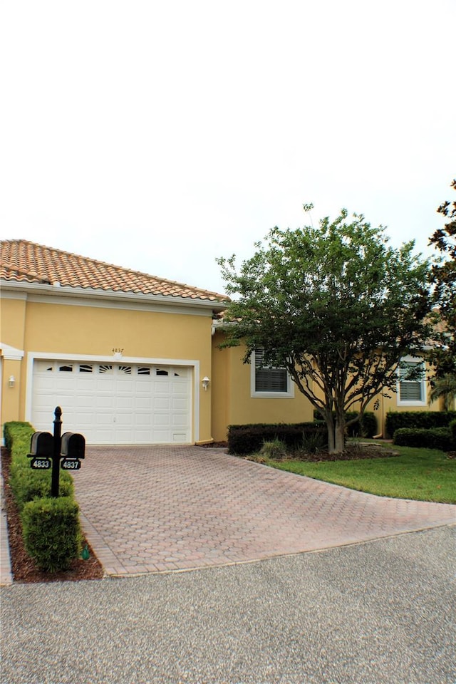 4837 Rainbow Race, New Port Richey, FL 34652 - view of front of property with decorative driveway, stucco siding, a garage, and a tile roof